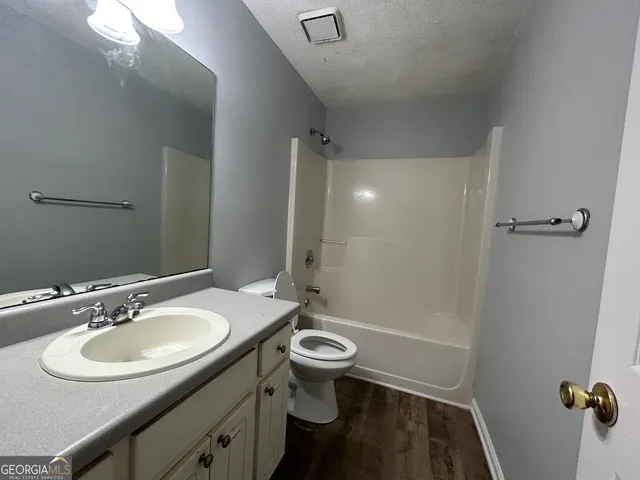 a bathroom with a sink a toilet a mirror and shower