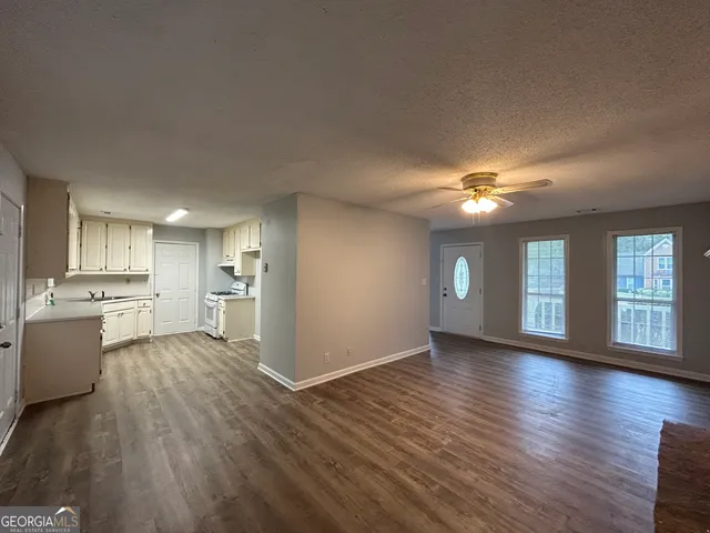 a view of empty room with wooden floor and window