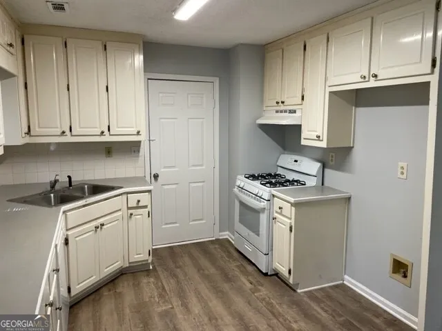 a kitchen with stainless steel appliances granite countertop a stove and a sink
