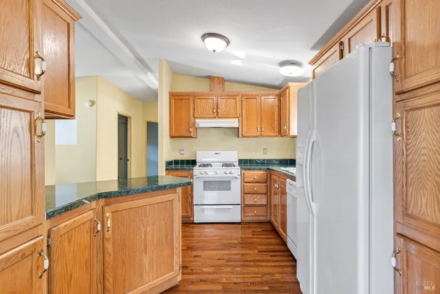 a kitchen with stainless steel appliances granite countertop a refrigerator and a stove