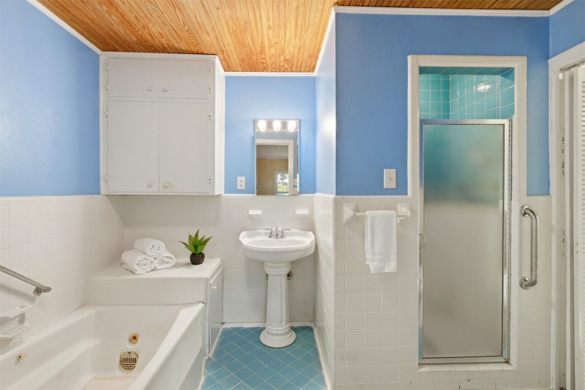 1506 Grace Street Taylor, TX 76574 - Photo 17 of 21 Secondary ensuite / full bath, a stall shower, a tub, and tile walls