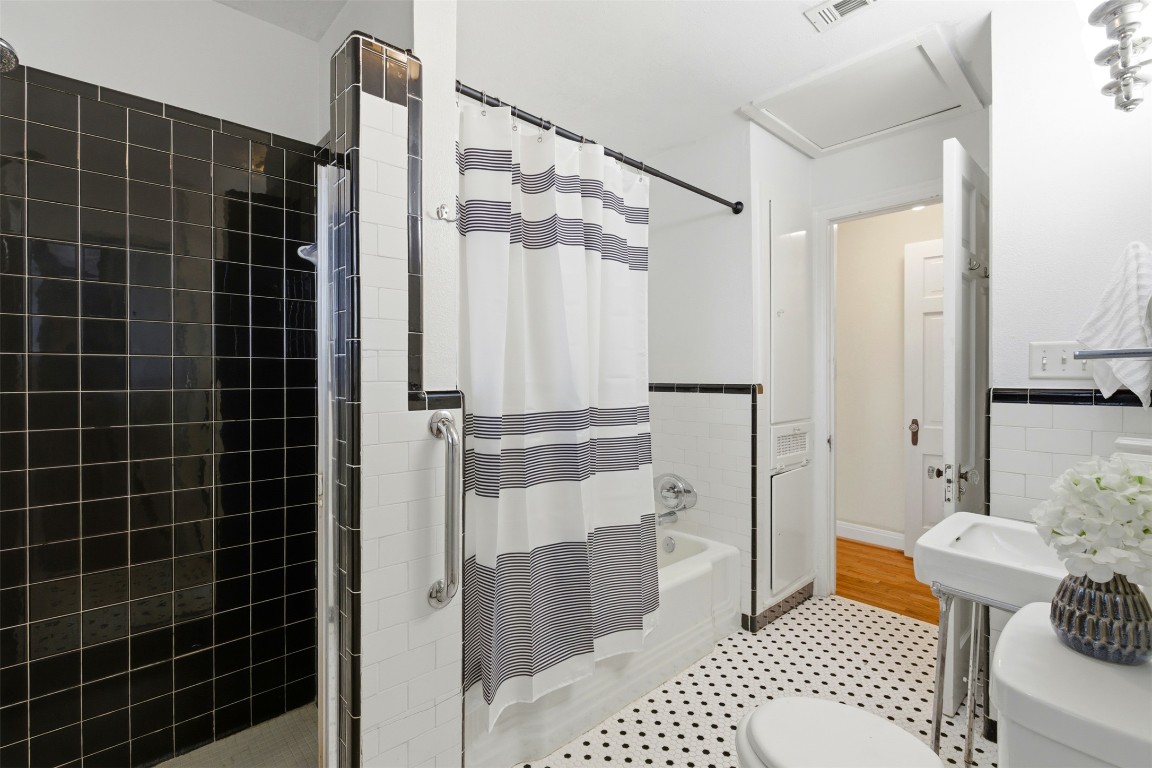 1506 Grace Street Taylor, TX 76574 - Photo 9 of 21 Bathroom with tile walls and shower / tub combo with curtain