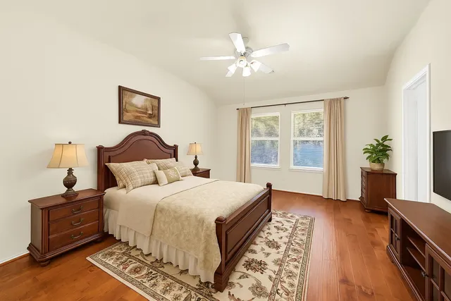 a bedroom with bed and wooden floor
