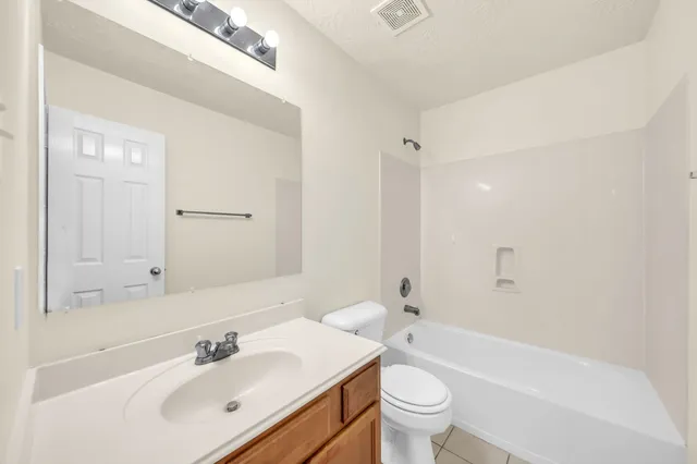 a bathroom with a sink a toilet and a large mirror