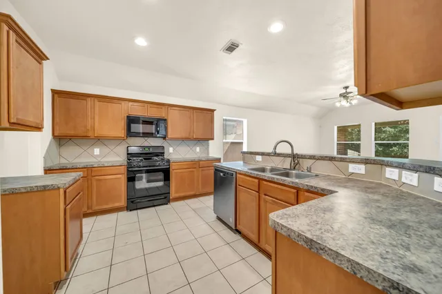 a kitchen with stainless steel appliances granite countertop a stove sink and cabinets