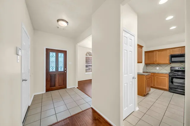 a open kitchen with stainless steel appliances a refrigerator and stove top oven