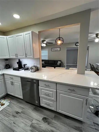 a kitchen with a sink cabinets and wooden floor