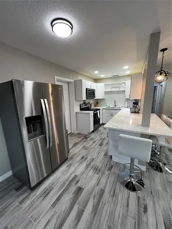 a kitchen with stainless steel appliances a refrigerator a sink dishwasher a stove with wooden floors