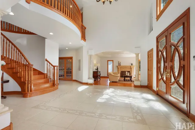 a dining room with wooden floor a chandelier a wooden table and chairs