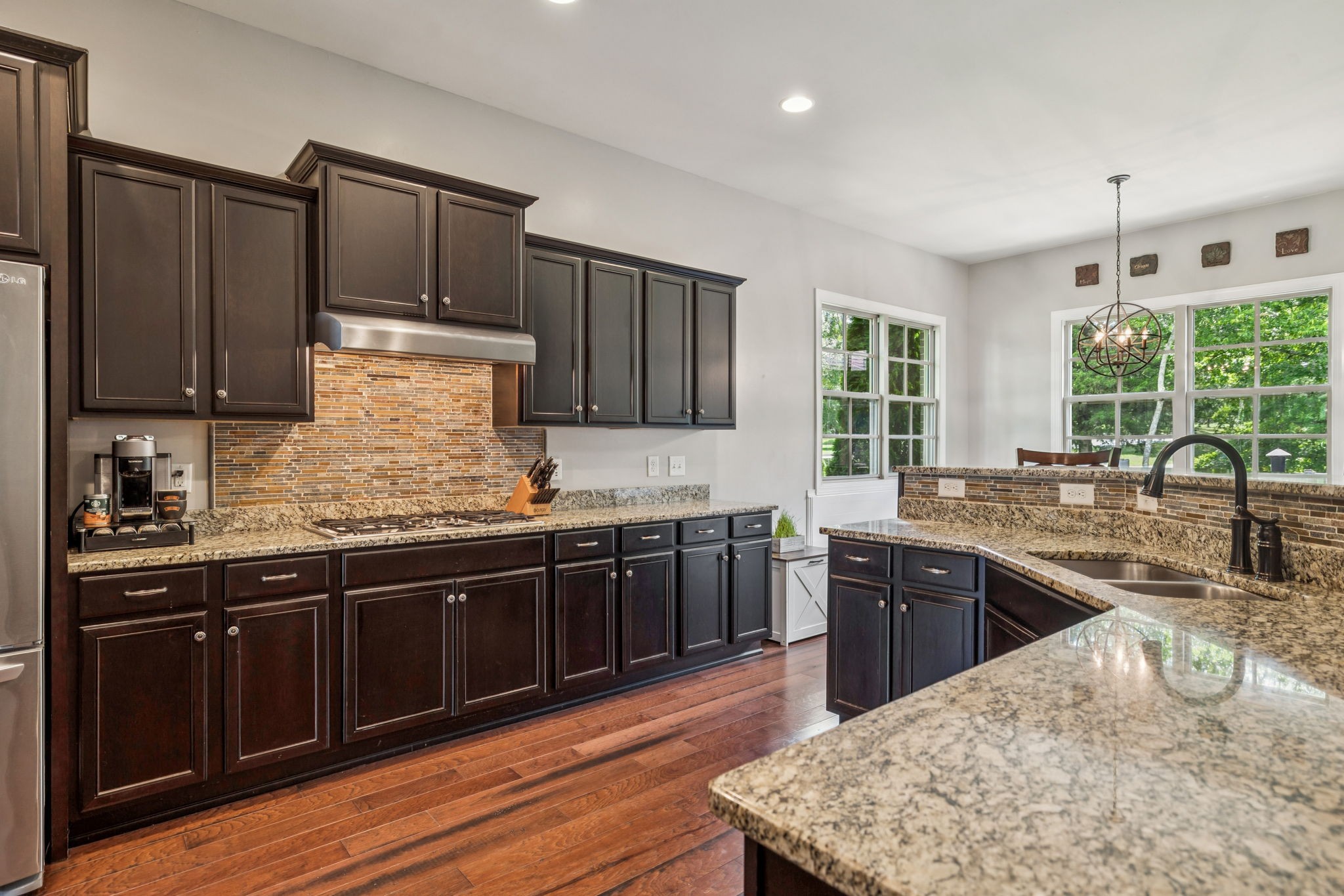 1501 Registry Row Arrington, TN 37014 - Photo 14 of 77 a kitchen with stainless steel appliances granite countertop wooden cabinets a stove top oven a sink and dishwasher with wooden floor