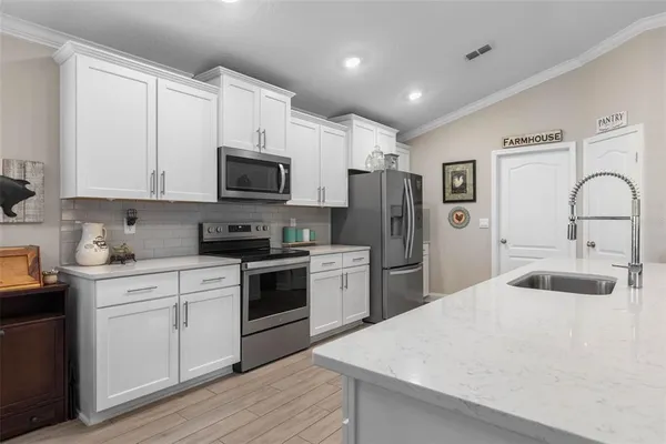 a kitchen with a refrigerator a stove top oven a sink and cabinets