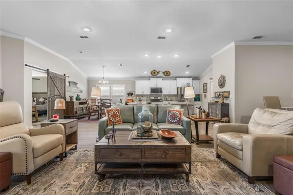a living room with lots of furniture and kitchen view