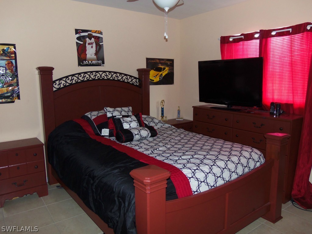 462 Rajah Street Lehigh Acres, FL 33974 - Photo 11 of 17 a bedroom with a bed and a flat screen tv