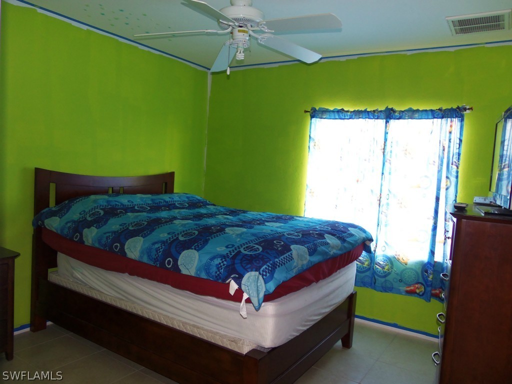 462 Rajah Street Lehigh Acres, FL 33974 - Photo 15 of 17 a bed sitting in a bedroom next to a window