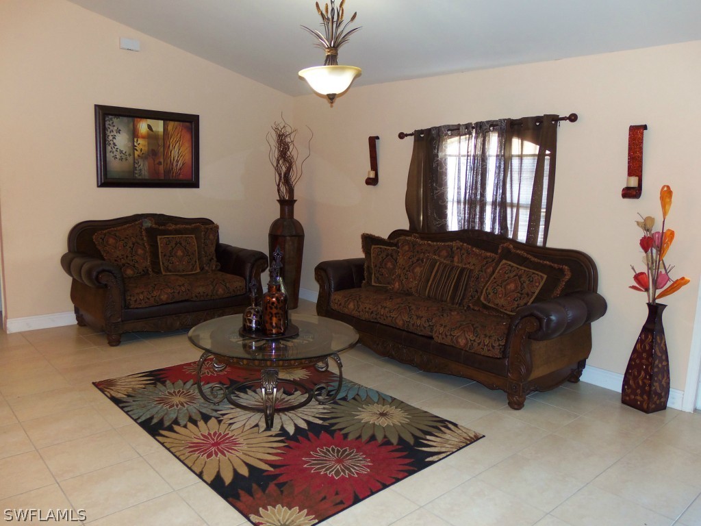 462 Rajah Street Lehigh Acres, FL 33974 - Photo 4 of 17 a living room with furniture and a chandelier