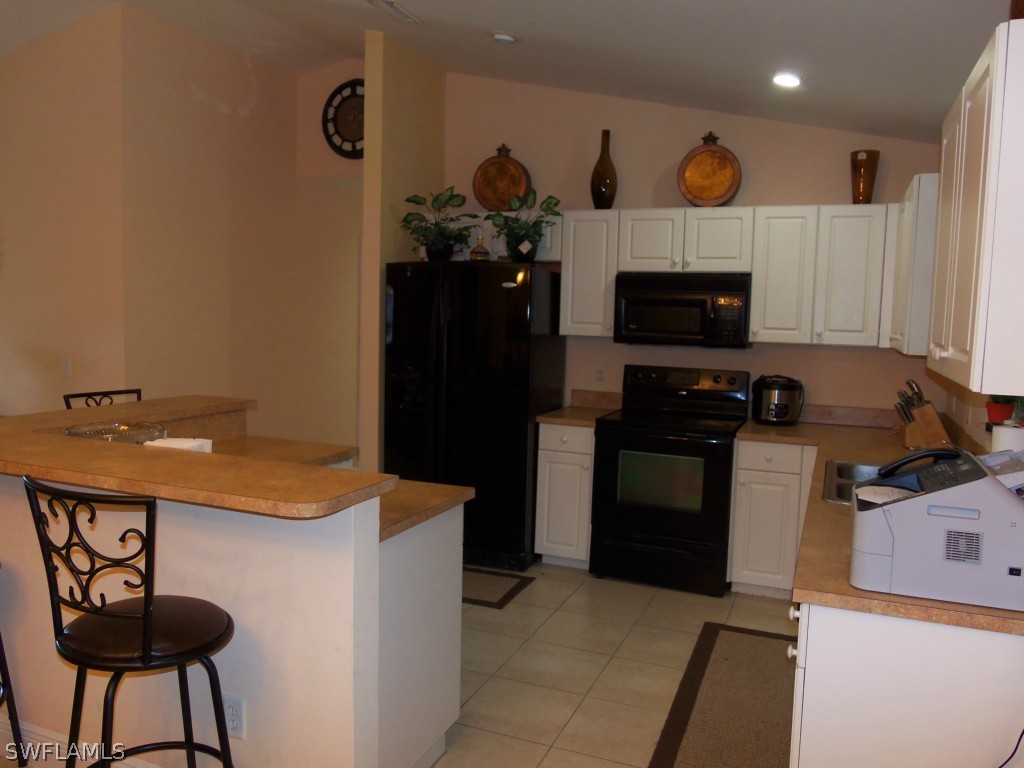 462 Rajah Street Lehigh Acres, FL 33974 - Photo 6 of 17 a kitchen with a refrigerator and a stove top oven