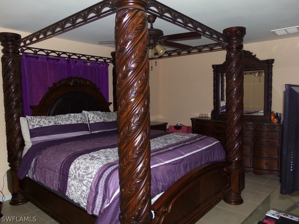 462 Rajah Street Lehigh Acres, FL 33974 - Photo 8 of 17 a bed sitting in a bedroom next to a lamp