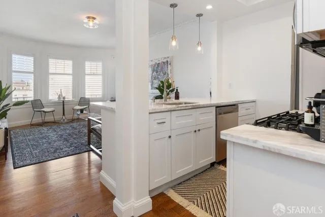 a kitchen with a sink stove and wooden floor