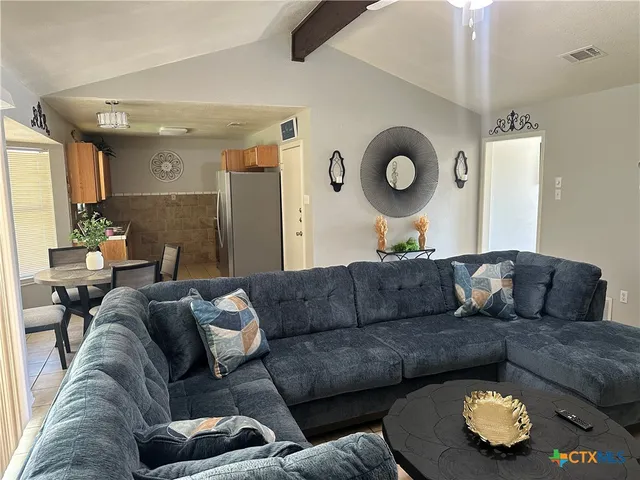 a living room with furniture and a mirror