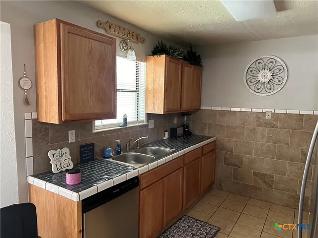 a kitchen with stainless steel appliances granite countertop a sink stove and cabinets