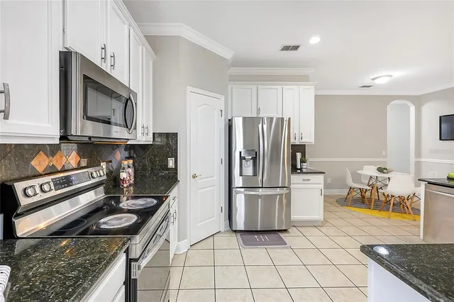 a kitchen with granite countertop a stove a refrigerator and a sink
