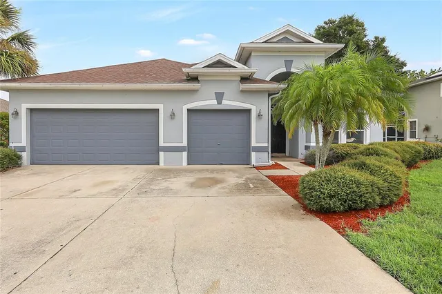 a front view of a house with a garden and plants