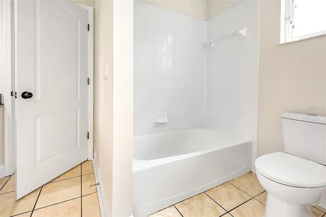 a white toilet sitting next to a bath tub