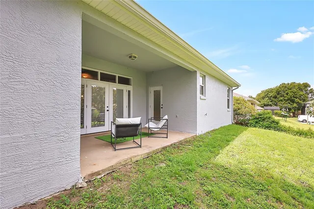 a view of a house with backyard and sitting area