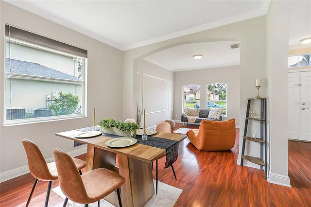 a dining room with furniture window and wooden floor