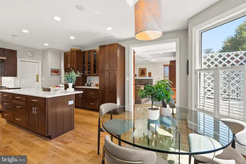 a kitchen with a refrigerator and a view of living room
