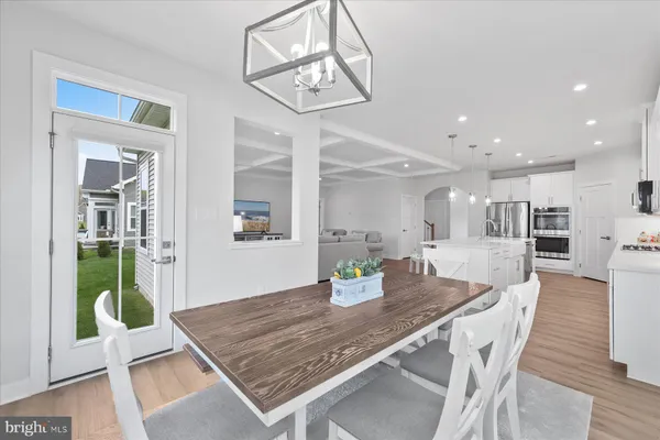 a dining room with wooden floor and chandelier