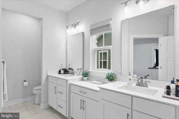 a bathroom with a double vanity sink mirror and toilet