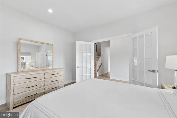 a bedroom with a bed and a mirror on dresser