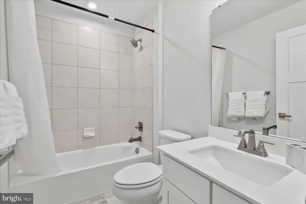 a bathroom with a sink toilet tub vanity and shower