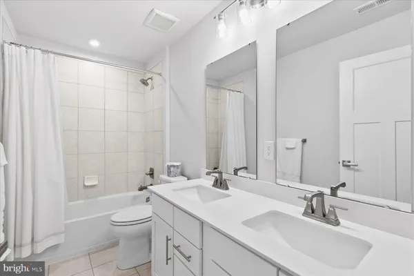 a bathroom with a double vanity sink toilet and shower