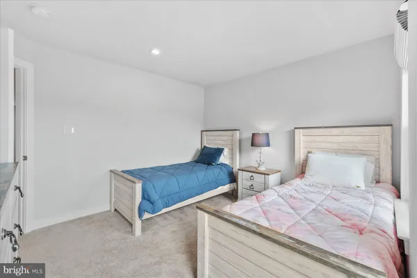a bedroom with two beds and a dresser