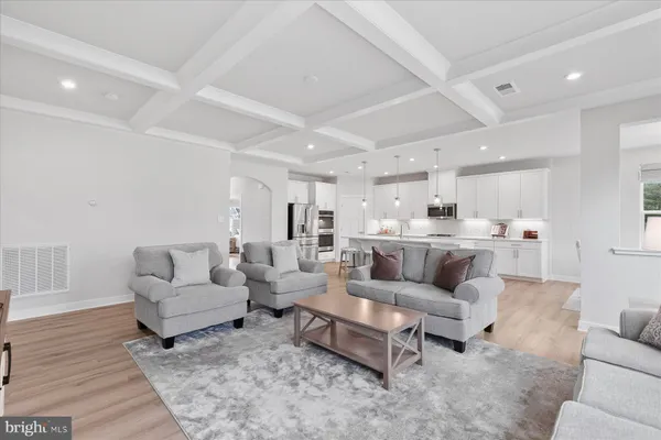 a living room with furniture and view of kitchen
