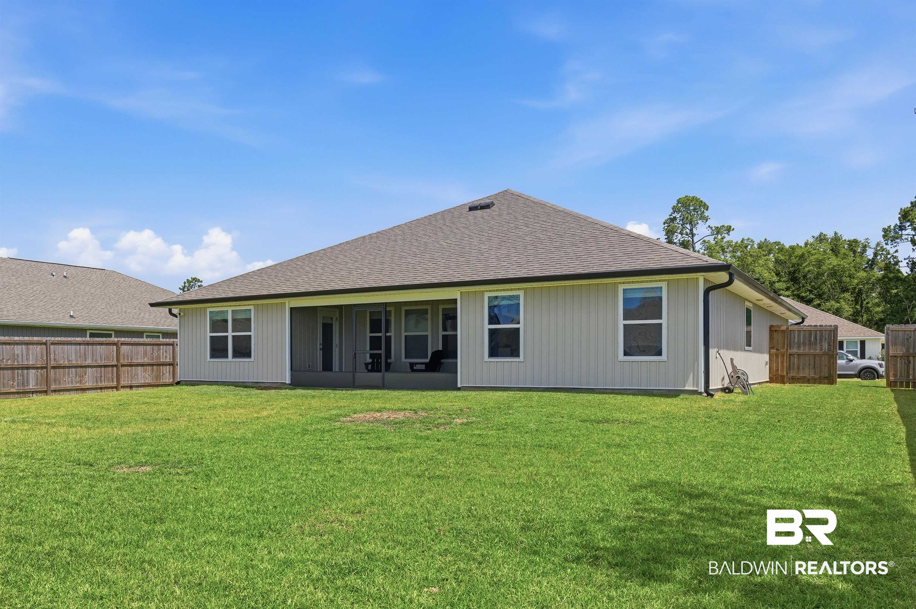 3213 Camino Real Loop Lillian, AL 36549 - Photo 6 of 61 Spacious backyard featuring a manicured lawn, a full wooden privacy fence, and a covered screened patio