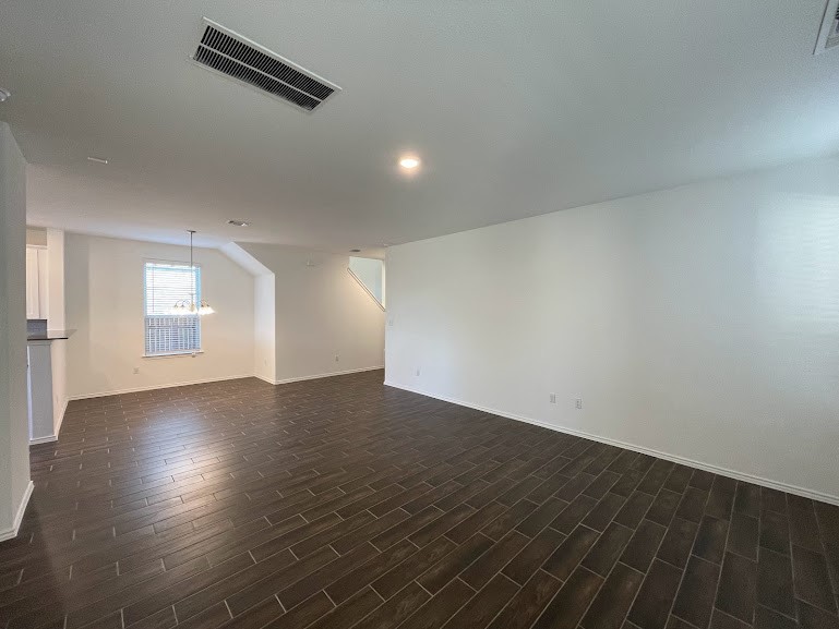 640 Pickrell Loop Georgetown, TX 78628 - Photo 9 of 36 an empty room with wooden floor and windows