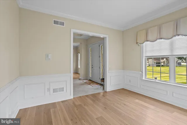 a view of a living room kitchen with a refrigerator and wooden floor