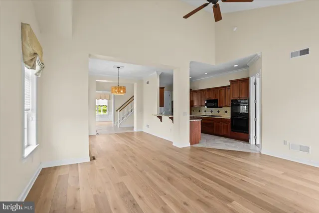 an empty room with kitchen and windows