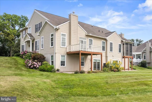 a view of a house with a big yard and a large tree