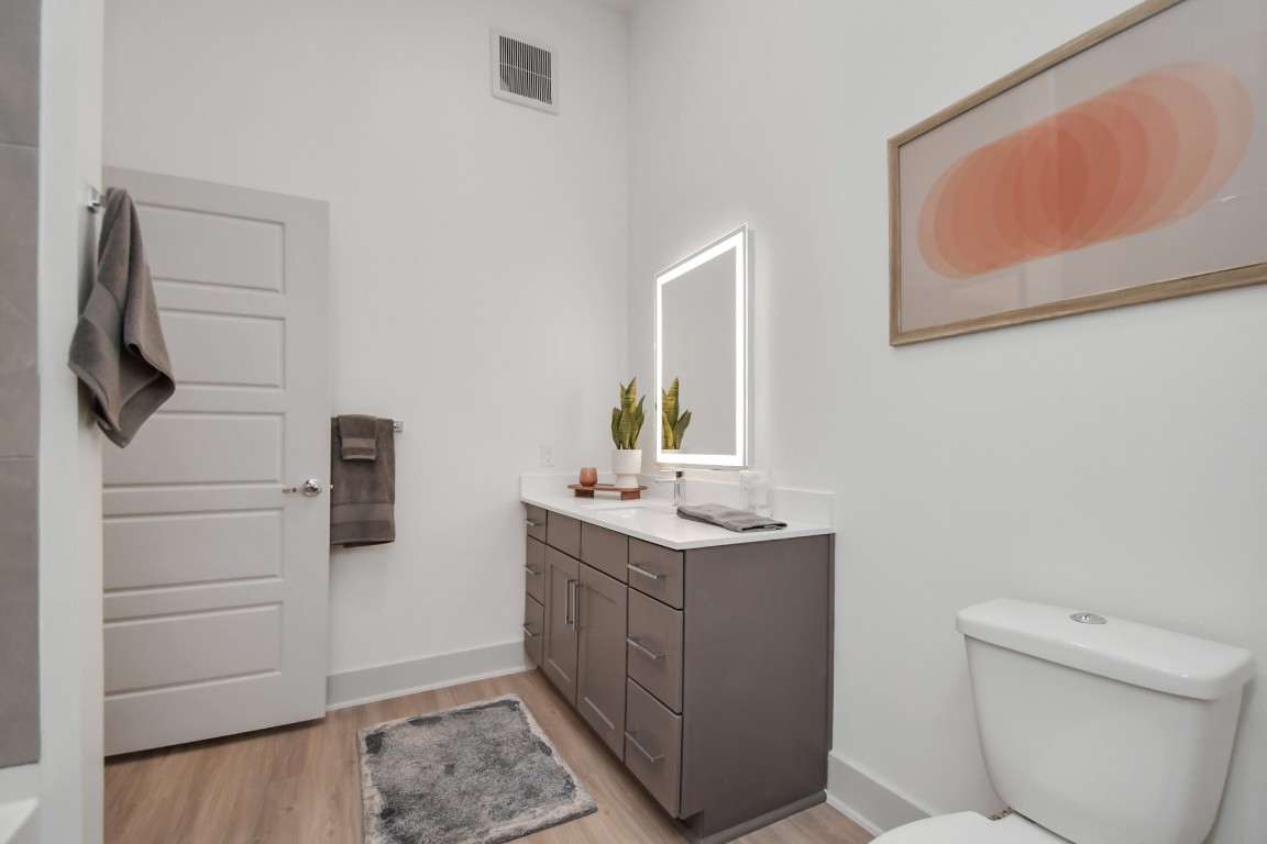 1617 Enid Street, Unit 318 Houston, TX 77009 - Photo 21 of 50 a bathroom with a toilet a sink a vanity and mirror