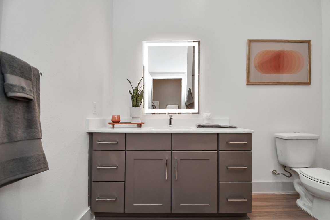 1617 Enid Street, Unit 318 Houston, TX 77009 - Photo 23 of 50 a bathroom with a toilet a sink a vanity and mirror