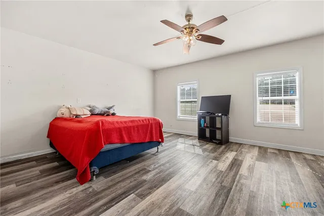 a living room with furniture a ceiling fan and a window