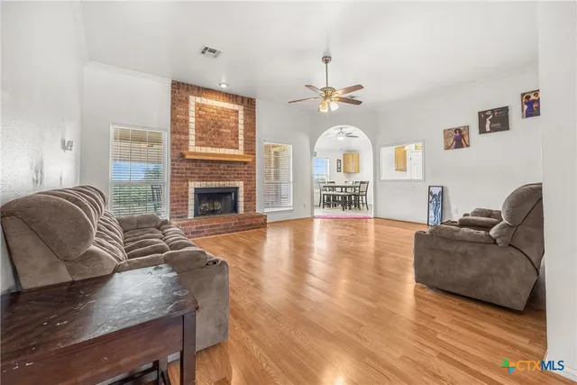 a living room with furniture fireplace and wooden floor