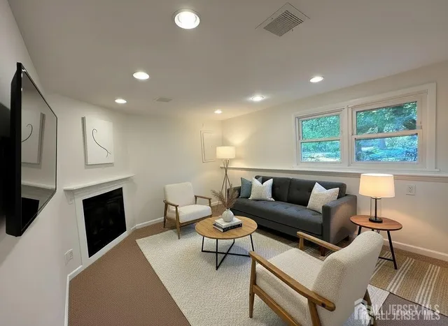 a living room with furniture a fireplace and a flat screen tv