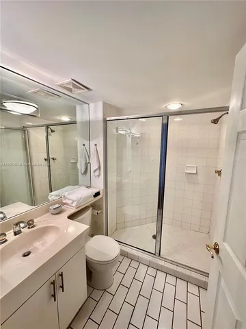 a bathroom with a sink mirror toilet and shower