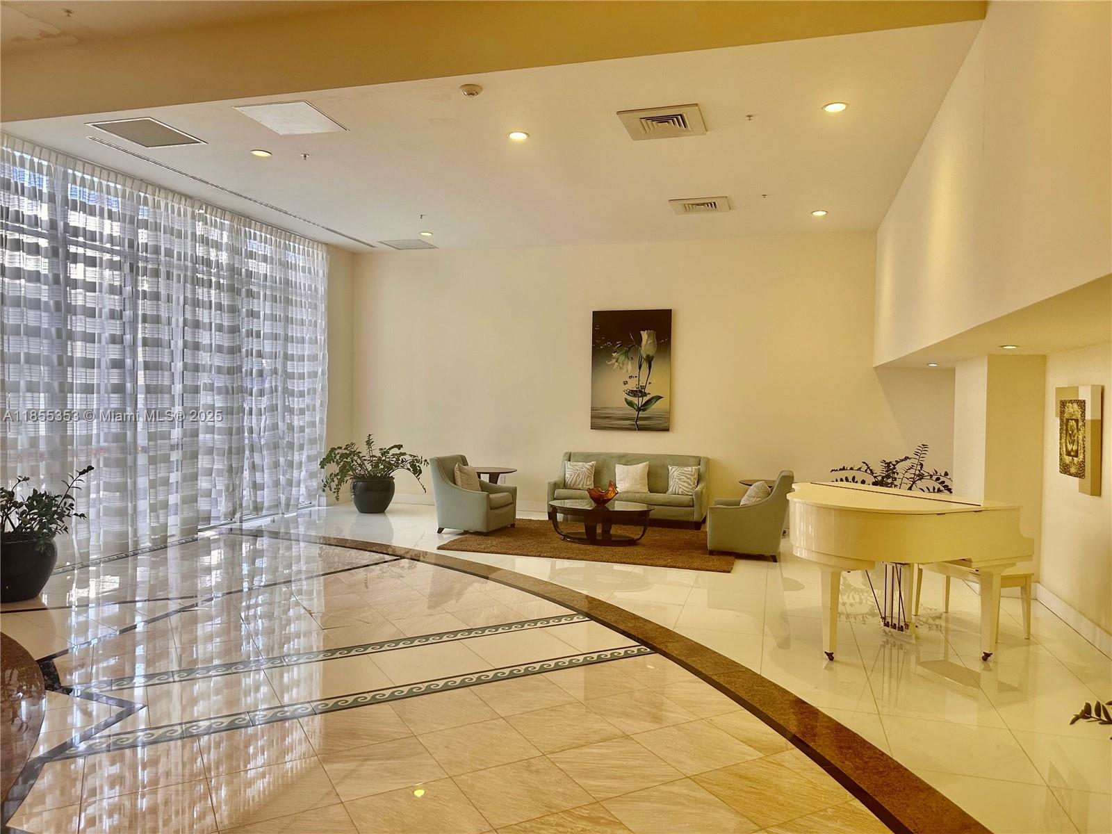 6301 Collins Avenue, Unit 806 Miami Beach, FL 33141 - Photo 19 of 26 a living room with a couch and potted plant