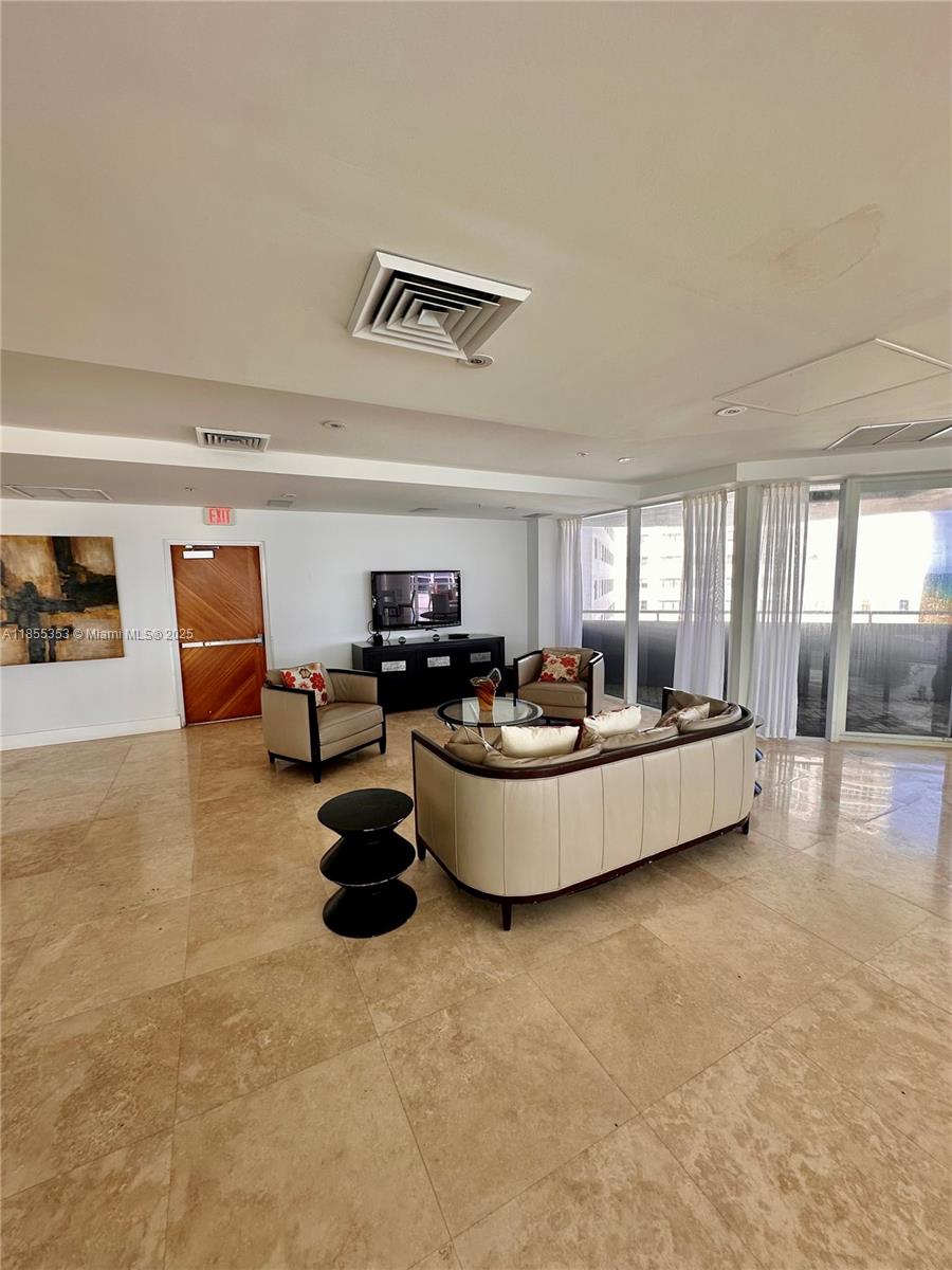 6301 Collins Avenue, Unit 806 Miami Beach, FL 33141 - Photo 21 of 26 a living room with furniture and a flat screen tv